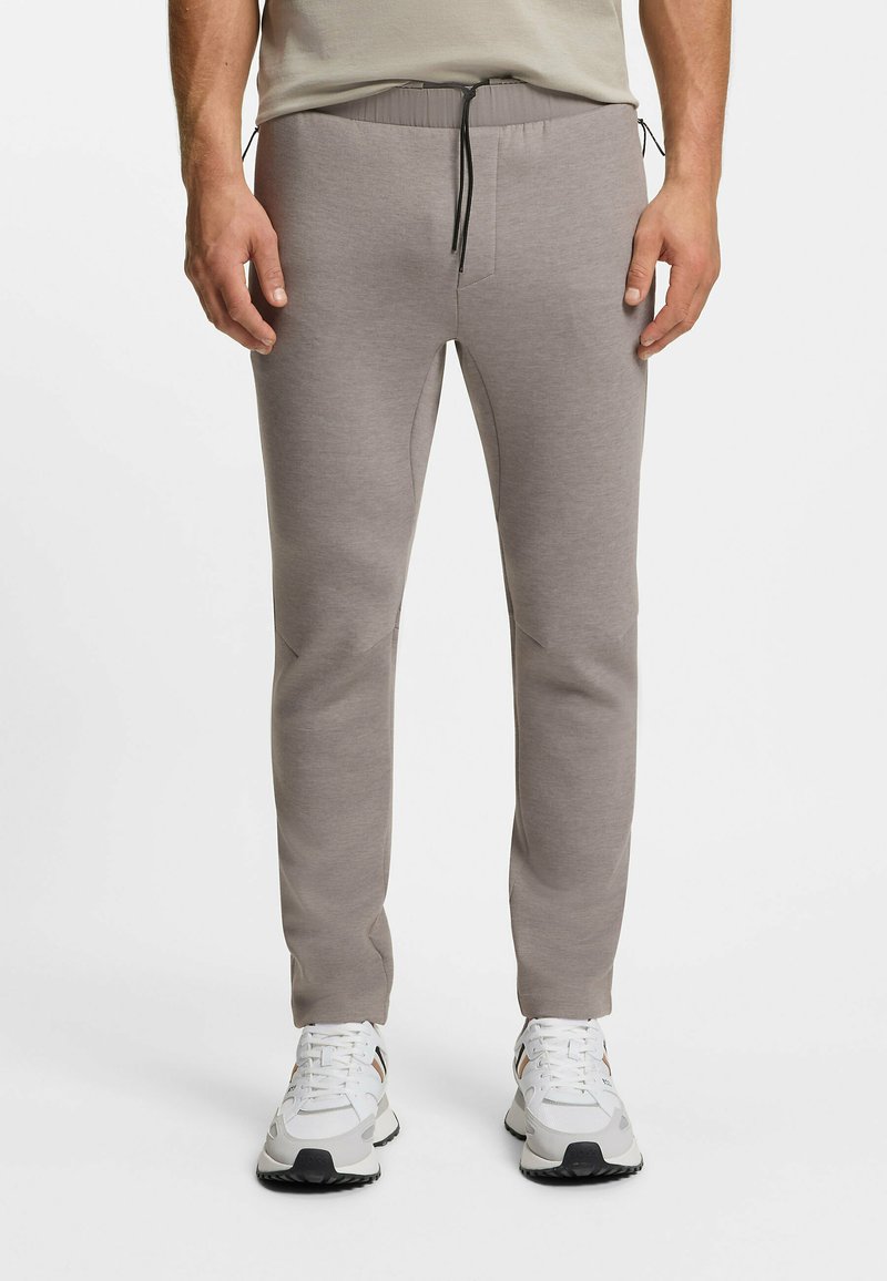 Hellgraue Jogginghosen mit elastischem Bund, Kordelzug und schlanker Passform. Hergestellt aus weichem, strukturiertem Stoff mit Seitentaschen.