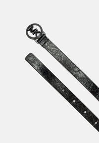 Zwarte leren riem met een gepeikt afwerking, uitgerust met een ronde metalen gesp met logo. Inclusief verstelbare gaten langs de band.
