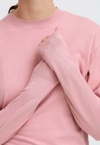 Rosa stickad tröja med långa ärmar, ribbad halsringning och muddar, med en mjuk, slät yta och en figurnära silhuett.