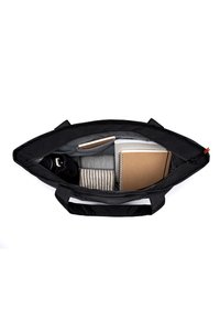 Svart toteväska med grå foder, som visar en anteckningsbok, randig tröja, vattenflaska och andra föremål inuti. Utformad för funktionalitet och förvaring.