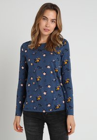 T-shirt a maniche lunghe in morbido tessuto blu navy, con un motivo floreale di fiori gialli e rosa, scollo rotondo e vestibilità comoda.
