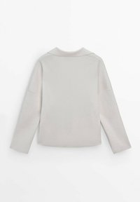 Pull gris clair avec un col haut, des épaules tombantes et de longues manches. Fabriqué en tissu lisse et doux avec un design minimaliste.