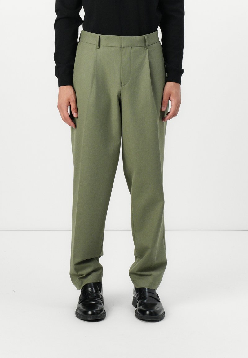 Green tailored trousers with a straight-leg fit, featuring a smooth texture, crease down the front, and subtle pleats at the waistband.