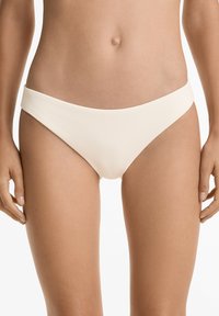 Svetlo bež rebrasti bikini spodnji del z širokim pasom, trikotnim izrezom in gladko teksturo. Brez okrasnih elementov ali vzorcev.