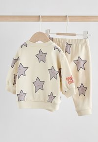 Sweat-shirt jaune et pantalon assorti avec motifs d'étoiles grises ; texte « cool friends » sur le poignet ; tissu doux, taille élastique, design décontracté.