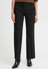 Czarne dopasowane spodnie z prostą nogawką, wykonane z gładkiego materiału. Posiadają kieszenie z przodu oraz czysty pas.