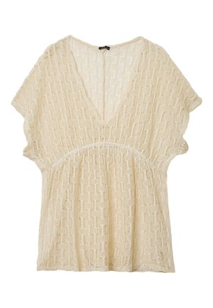 Haut beige à manches courtes en tricot avec un col en V et un motif ajouré texturé.