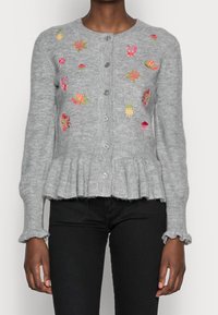 Szary dzianinowy kardigan o prążkowanej fakturze, z kwiatową haftem w kolorze różowym i żółtym, zapinany na pięć guzików, z falbaną u dołu. Rękawy zakończone falbanami.