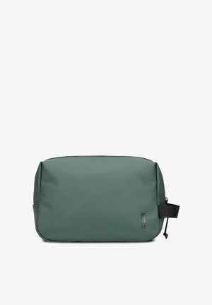 Groene toilettas met een gladde, matte textuur, rechthoekige vorm en ritsafsluiting; beschikt over een zwarte strap en branding aan de zijkant.