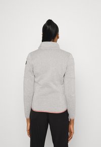Grau Fleece-Jacke mit hohem Kragen, ausgestattet mit einer glatten Textur und einem kontrastierenden roten Saum an der Unterseite und an den Ärmeln.