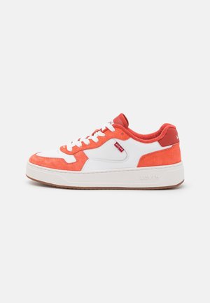 Low-top sneaker with white leather and coral suede panels, white laces, red fabric lining, rubber sole, and Levi's red tag on side.
