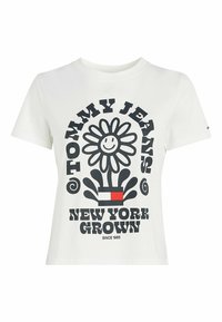 Bílá bavlněná trička s černým grafickým designem usměvavého květu, textem "TOMMY JEANS NEW YORK GROWN" a červenými a modrými akcenty.