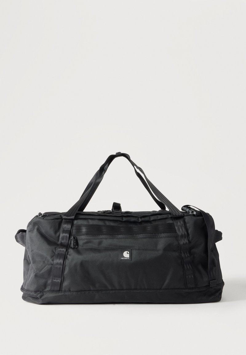 Μαύρη τσάντα Carhartt τύπου duffel με δύο χερούλια, εμπρόσθια τσέπη με φερμουάρ και ορθογώνιο σχήμα σε απλό λευκό φόντο.