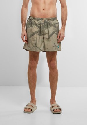 Kamuflasjemønstrede, lette shorts med elastisk livlinje og en liten logo-lapp på siden. Fargeskjemaet har jordfarger.