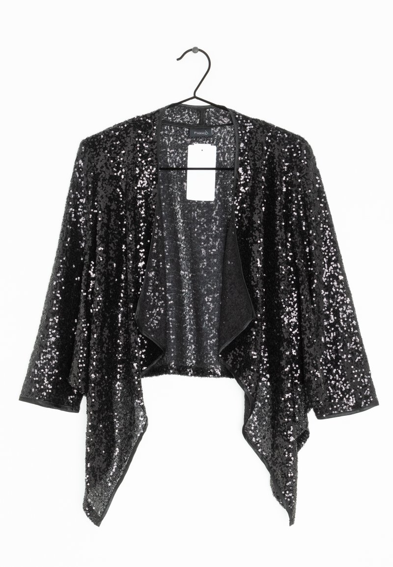 Veste noire à sequins, ouverte sur le devant, avec manches longues et ourlet asymétrique, suspendue à un cintre sur un fond blanc.
