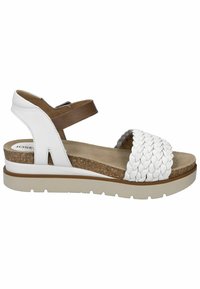White leather sandals with a braided strap, brown ankle band, cork footbed, and a light rubber sole. Low wedge design.