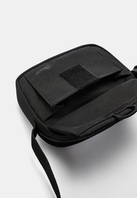 Sorte lynlåspose lavet af holdbart stof, med en Velcro-lukning og indvendig lomme til organisering. Minimalistisk design.