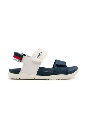 Sandalia ajustable en azul marino y blanco con correas de velcro, suelas texturizadas y un diseño ligero. Presenta un acento de correas en rojo y azul contrastantes.