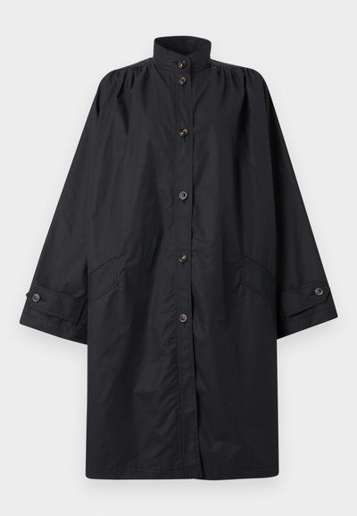 Imperméable long noir avec col montant, fermeture avant à boutons, poches latérales et poignets à boutons, présenté à plat sur fond blanc.