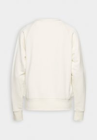 Krämfärgad sweatshirt med en jämn textur, med långa raglanärmar och en avslappnad passform. Inga synliga dekorationer eller mönster.