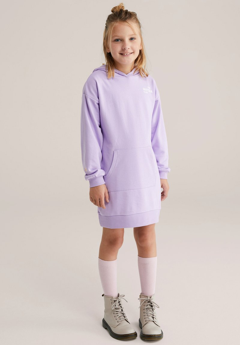 Vestito felpa con cappuccio lilla con tasca a marsupio, maniche lunghe e polsini a coste, abbinato a stivali grigi con lacci e calzini rosa chiaro al ginocchio.