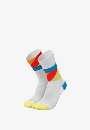 Bunte Knöchelsocken mit weißem Grund, verziert mit geometrischen Mustern in Blau, Gelb, Orange und Pink. Hergestellt aus dehnbarem, atmungsaktivem Stoff.