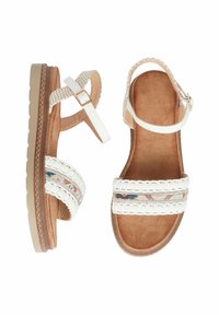 Sandali bianchi con cinturini intrecciati, dettagli metallici decorativi, soletta marrone imbottita e suola beige texturizzata. Cinturino alla caviglia regolabile.