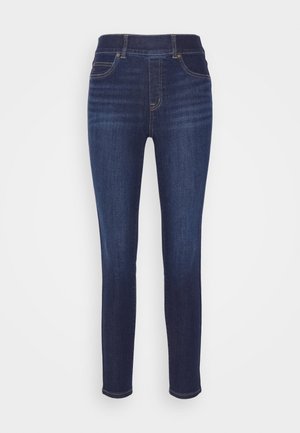 Jean slim fit bleu foncé à taille haute. Dispose de quatre poches et de surpiqûres dorées contrastées le long des coutures. Texture en denim douce.