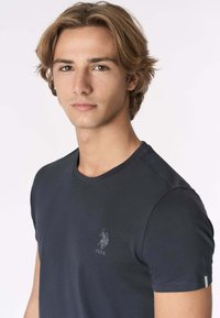 Maglietta a maniche corte blu navy in cotone, con scollo rotondo e piccolo logo ricamato sul petto a sinistra.