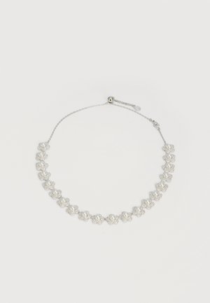 Collier en chaîne argentée avec des montures en forme de fleurs espacées régulièrement, chacune contenant une perle blanche centrale entourée de petits cailloux clairs.