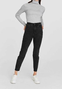 Czarne jeansy skinny z wysokim stanem wykonane z elastycznego materiału o gładkiej fakturze, z klasycznym pięciopocketowym designem oraz zwężającymi się nogawkami.