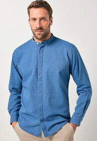 Overhemd met knoopsluiting in lichtblauwe denim met een staande kraag, lange mouwen en een rechte zoom. Gladde textuur met subtiel verticaal patroon.