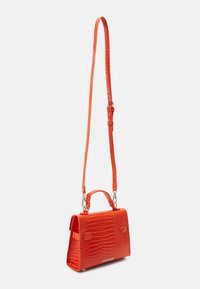 Sac à main en cuir rouge avec un motif crocodile, forme structurée, bandoulière amovible et anse supérieure. Équipé de quincaillerie dorée et de marquage.