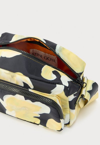 Black floral zippered bag featuring yellow abstract flower patterns, nylon material, an orange interior, and a side strap for carrying.