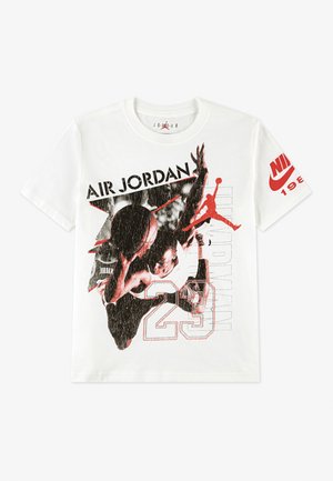 Camiseta blanca con gráfico en negro y rojo de un jugador de baloncesto haciendo un mate, texto "Air Jordan 23" en el frente, y logo de Nike en rojo en la manga derecha.