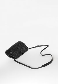 Borsa in pelle nera con superficie testurizzata, tracolla regolabile e forma arrotondata. Presenta una chiusura a scatto e un design minimalista.