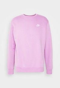 Jasnoróżowa bluza z długimi rękawami, okrągłym dekoltem i białym logo Nike na lewej piersi. Miękki materiał, proste wykończenie u dołu i ściągacze na mankietach.