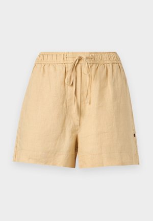 Pantalones cortos de lino beige con cintura elástica y cordón, de longitud hasta la mitad del muslo, ajuste relajado y pequeño logo bordado en el lateral.