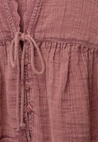 Rosa-bluse aus strukturiertem, zerknittertem Stoff mit einem mit Spitze besetzten Halsausschnitt, Bindebändern und Knopfverschlüssen auf der Vorderseite.
