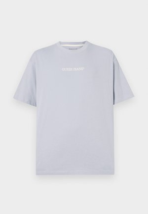 T-shirt de manga curta azul claro, feito de algodão, com um logótipo branco "GUESS JEANS" na frente. Decote redondo com um corte descontraído.