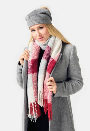 Gray knit beanie and a long scarf featuring a red and white check pattern. The scarf has frayed edges, worn over a gray coat.