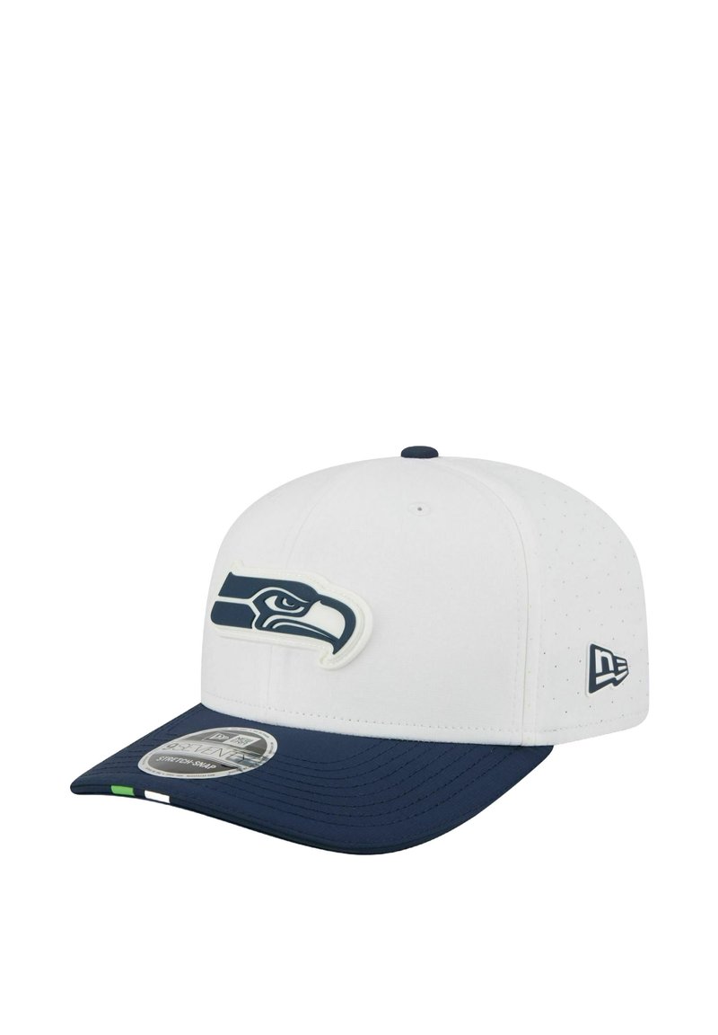 White and navy baseball cap featuring a stylized hawk logo on the front and a small emblem on the side.
