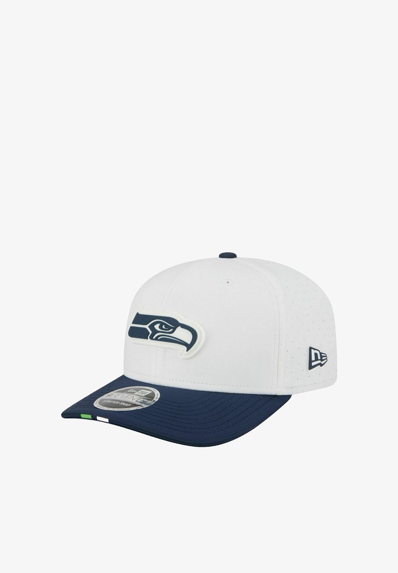 White and navy baseball cap featuring a stylized hawk logo on the front and a small emblem on the side.