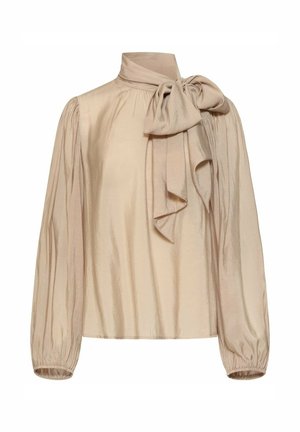 Beige blouse met lange mouwen met geplooide pofmouwen, hoge kraag en grote strik gestrikt aan de rechterkant van de hals.
