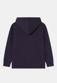Sweatshirt à capuche violet foncé avec des manches longues, des poignets côtelés et un ourlet droit, présenté de dos sur fond blanc.