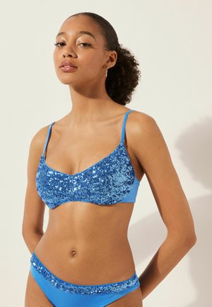 Blaues Bikini-Set mit einem gepailletteten Bralette mit verstellbaren Trägern und passenden gepailletteten Höschen; glattes, glänzendes Material, figurbetontes Design.