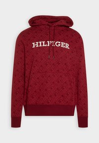 Sudadera con capucha roja con textura estampada, bolsillo frontal tipo canguro y texto "HILFIGER" en blanco en el pecho.