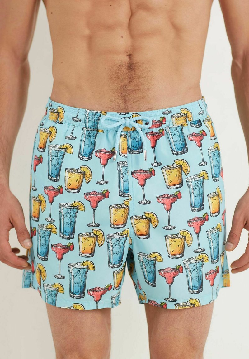 Un short de bain bleu avec un imprimé vibrant de divers cocktails, y compris des margaritas et des mojitos, avec des accents jaunes et rouges.