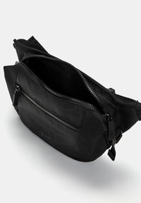 Sac banane noir en tissu texturé avec un motif hexagonal. Doté de deux zips et d'une sangle adjustable. Design compact et fonctionnel.