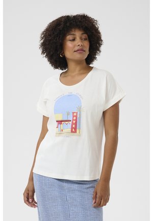 Cremefarbenes T-Shirt mit kurzen, aufgerollten Ärmeln und einem grafischen Druck, der ein Motel-Schild und Palmen in Blau und Rot zeigt.